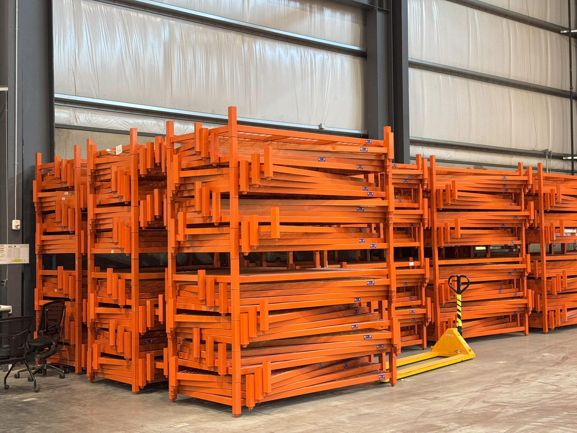 Large orange portable stack rack inventory staged in a warehouse